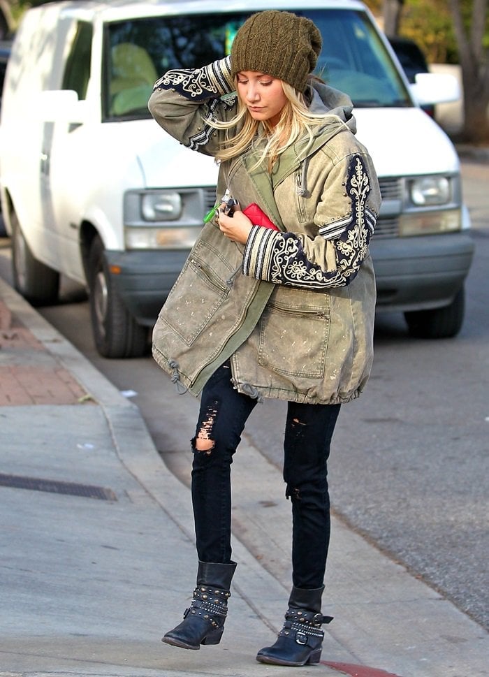 Ashley Tisdale rocked a military jacket with a gray top, black distressed denim jeans, and studded moto boots