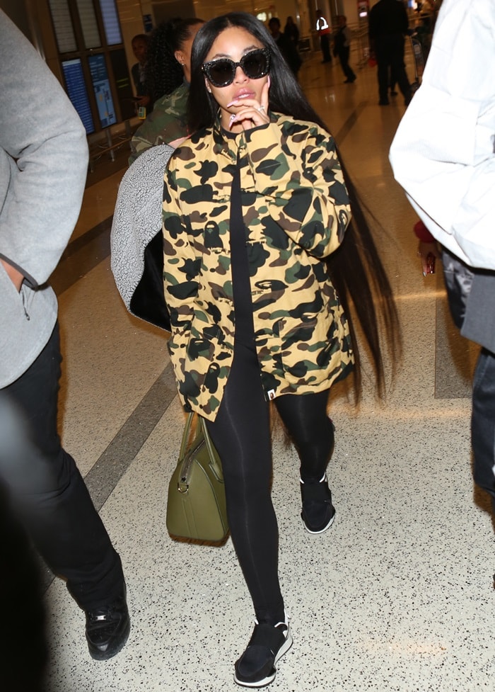 Blac Chyna effortlessly combines comfort and style, pairing her statement military jacket with versatile black leggings and stylish black and white sneakers