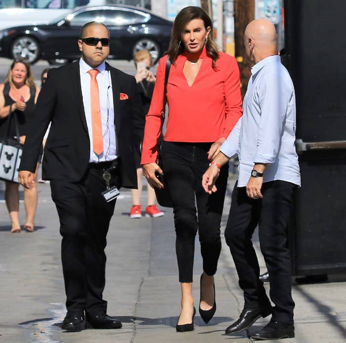 Caitlyn Jenner styled a red long sleeved top with black pants and matching pointy-toe pumps