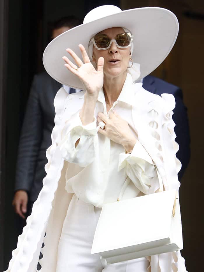 Celine Dion completed the look with an oversized white hat and unique half-frame sunglasses, exuding a regal and high-fashion presence during Paris Couture Week