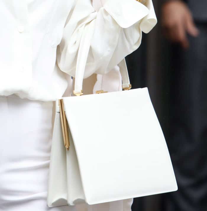 Celine Dion carries a sleek, structured white Céline Medium Clasp Tote, perfectly complementing her all-white ensemble