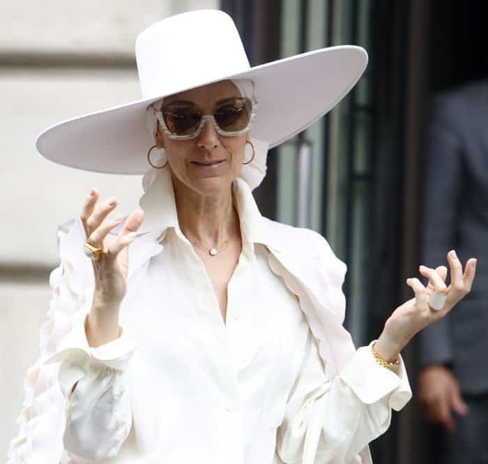 Celine Dion styled her all-white look with a large fedora hat and vintage sunglasses.