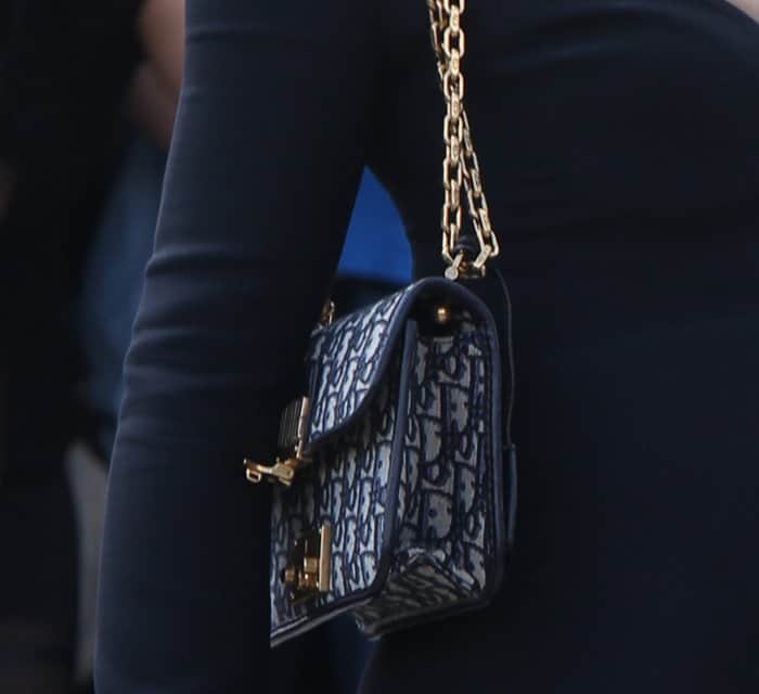Natalie Portman’s Dior shoulder bag features the brand’s signature navy monogram print, gold hardware, and a chain strap—adding vintage flair to her classic look