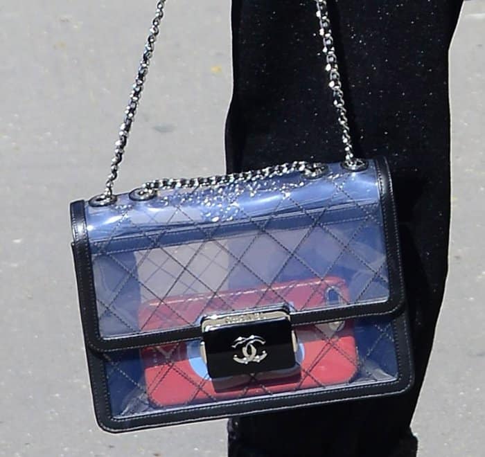 Claudia Schiffer’s transparent Chanel flap bag features quilted detailing, black leather trim, and silver-tone hardware—offering a playful peek at its contents