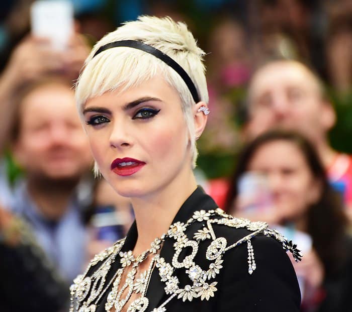 Cara completed her look with dazzling crystal ear crawlers, perfectly complementing the intricate detailing of her vintage-inspired capelet