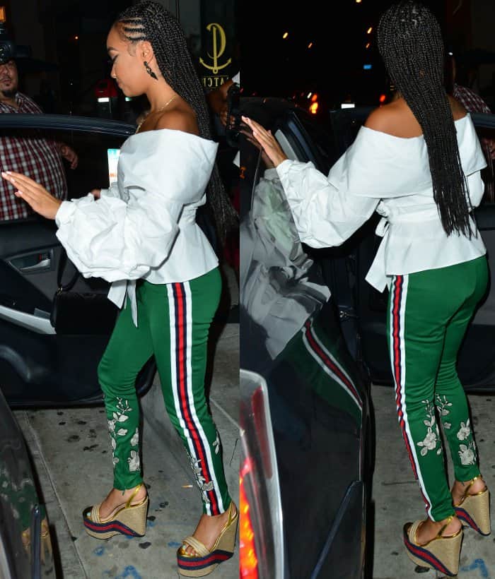 Leigh-Anne Pinnock wearing an off-shoulder wrap shirt, Gucci green jersey stirrup leggings, and Gucci metallic leather platform espadrilles