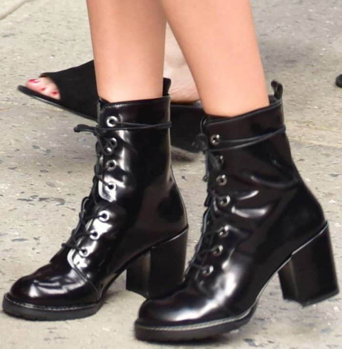 Another perspective of Millie Bobby Brown's fashion-forward footwear, showcasing the intricate details of Stuart Weitzman's 'Climbing' lace-up ankle boots