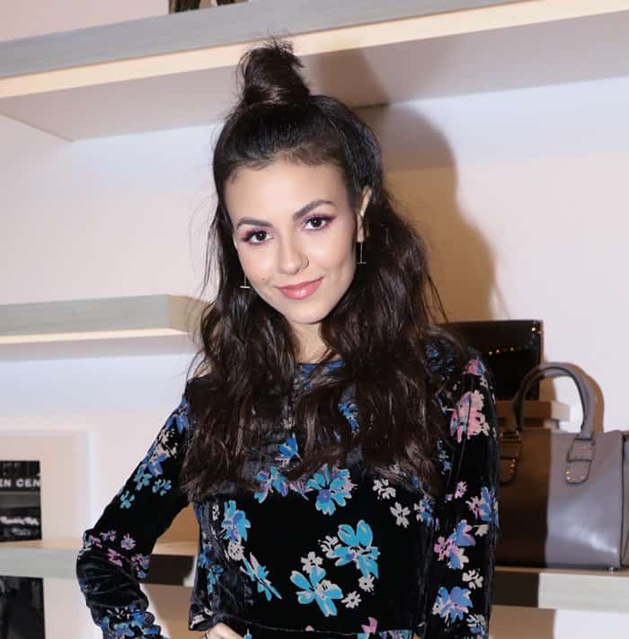 Victoria Justice tied her hair in a top knot, with half her hair falling over her shoulders