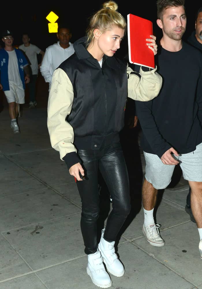 Hailey Baldwin covers her face as she heads to her car