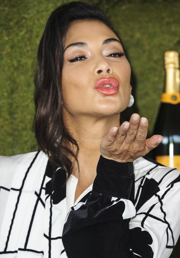 Nicole blows a kiss with coral lips