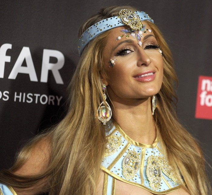 Paris Hilton channels Princess Jasmine in a jeweled, light blue costume adorned with intricate details and accessories