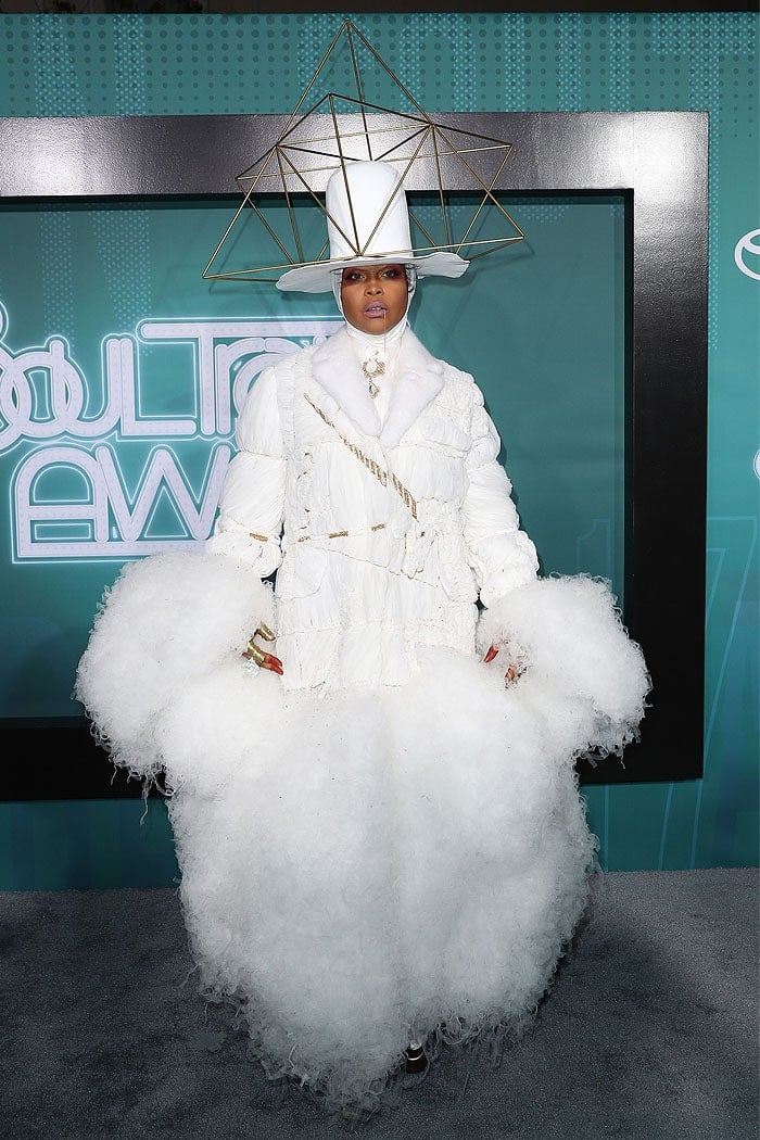 Erykah Badu's outfit featured a white suit-dress hybrid covered in voluminous, frayed fabric reminiscent of cotton candy, exuding avant-garde drama
