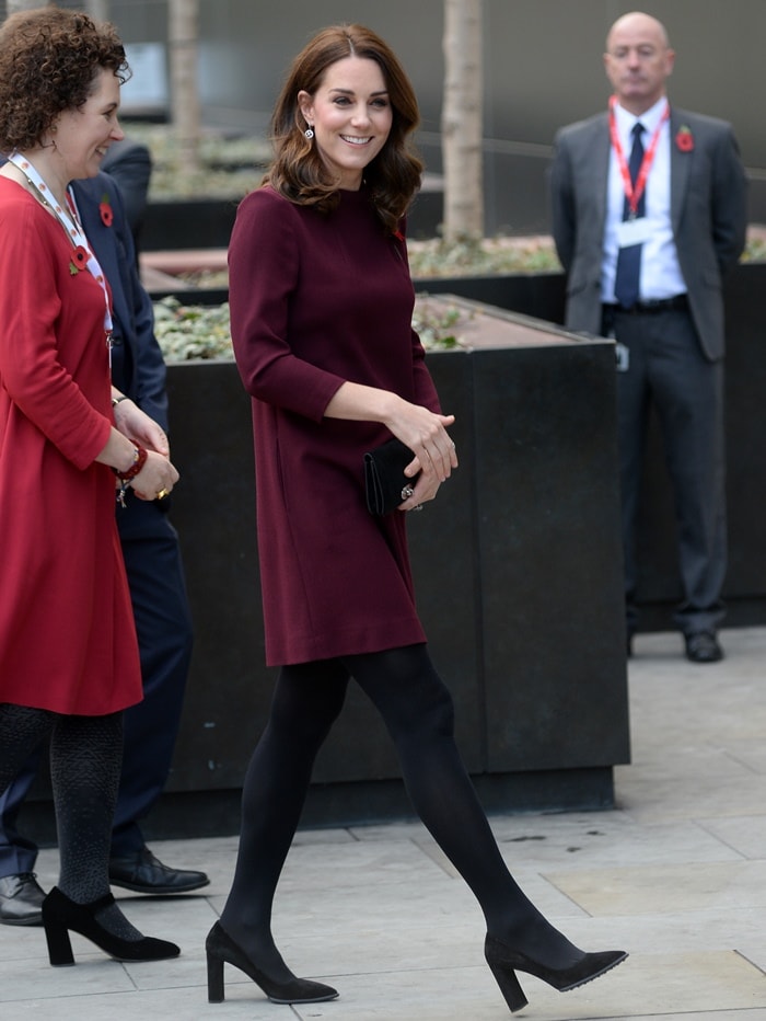 Kate Middleton stepped out in timeless elegance, pairing her plum Goat tunic dress with chic black suede block-heeled pumps from Tod’s, offering both style and comfort for the occasion