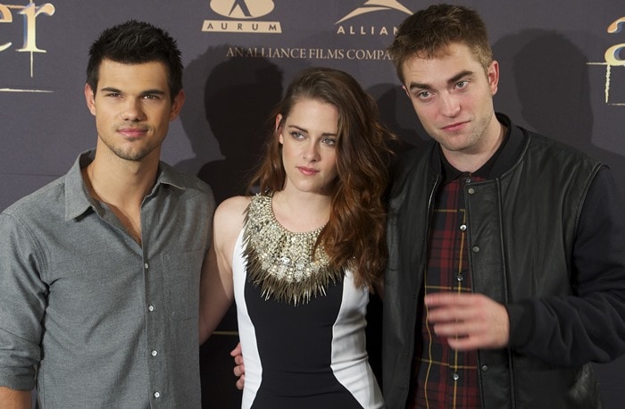 A Trio of Twilight Stars: Taylor Lautner, Kristen Stewart, and Robert Pattinson strike a pose during the Madrid photo call for The Twilight Saga: Breaking Dawn — Part 2, showcasing their camaraderie and star power