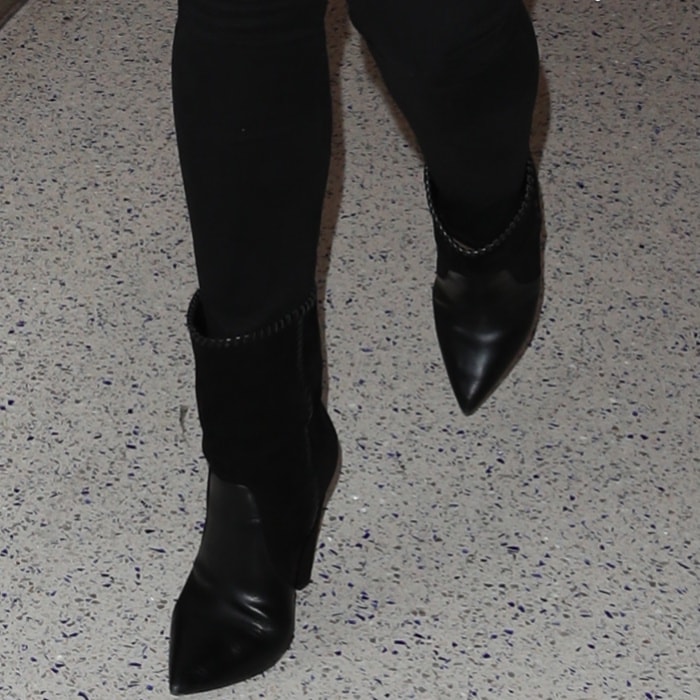 Chrissy Teigen rocks black Saint Laurent boots with cone wedge heels