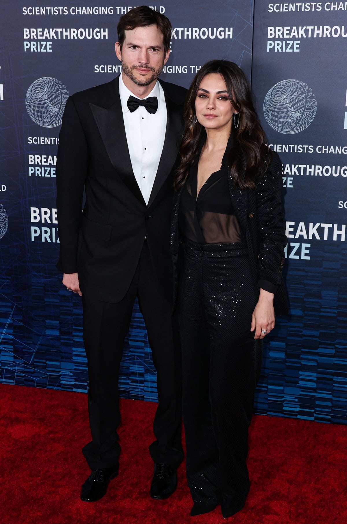 shton Kutcher wore a tuxedo while Mila Kunis donned a sparkling Brunello Cucinelli black suit and a sheer blouse at the 9th Annual Breakthrough Prize Ceremony