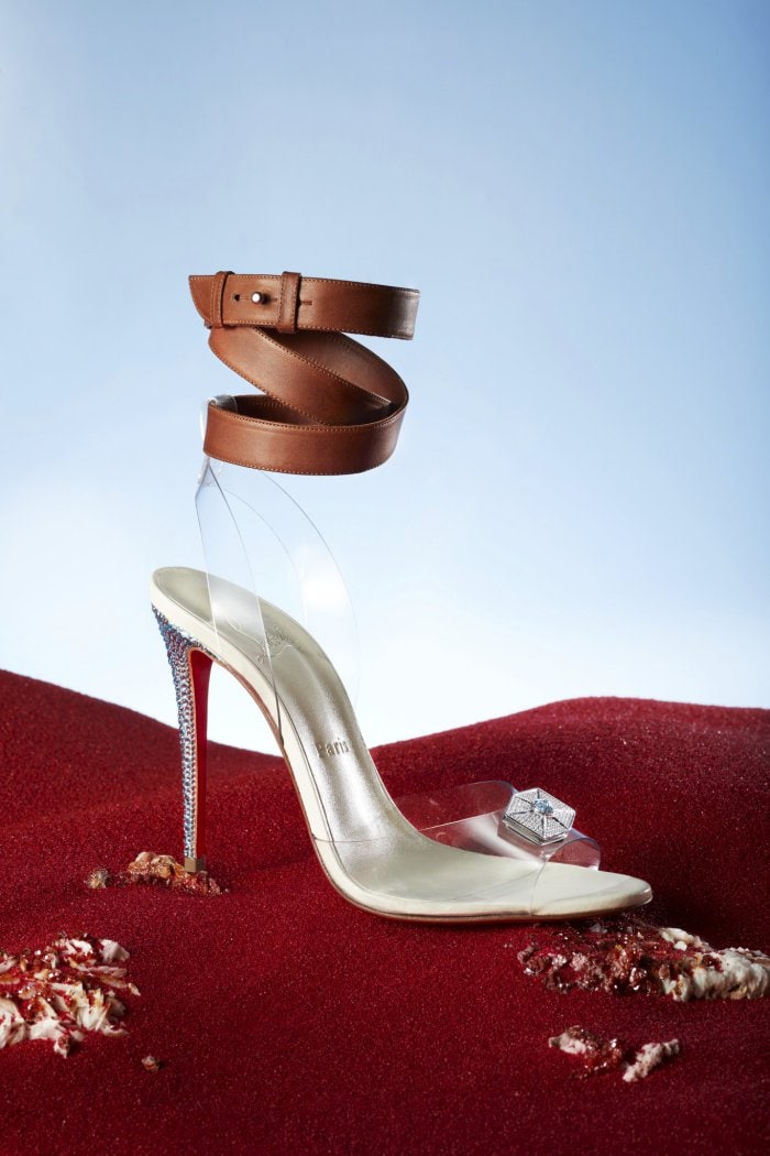 Christian Louboutin's "Rey" sandals feature brown leather ankle straps from her costume's harnesses, a translucent PVC design influenced by her Jedi powers, and blue strass heels mirroring her lightsaber's color