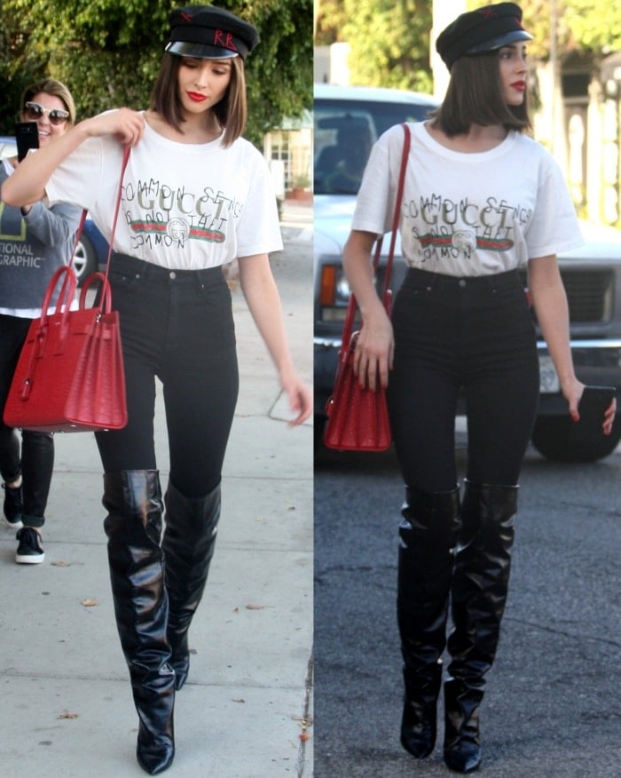 Olivia Culpo wearing a Gucci "Coco Capitan" logo shirt, GRLFRND "Kendall" skinny jeans, and Saint Laurent "Niki" glossed-leather knee boots
