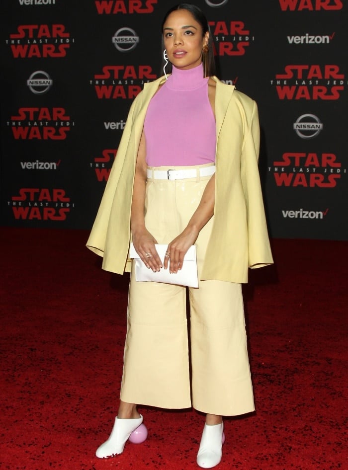 Tessa Thompson styled her yellow suit with a pink turtleneck and a white leather clutch