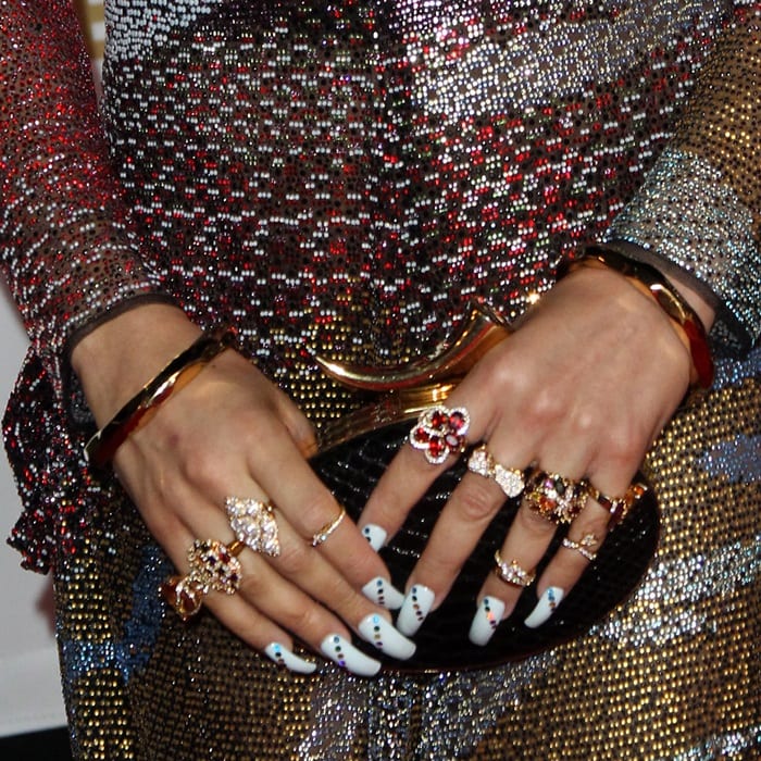 Andra Day showcasing her Giuseppe Zanotti clutch and elegant rings, completing her glamorous look with a chic manicure