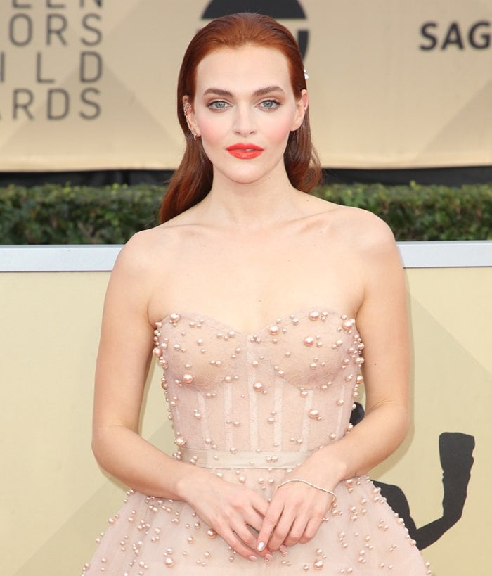 Madeline Brewer's strapless dress, adorned with delicate pearl beading and featuring a teal length, layered design with a bustier bodice, was a true showstopper