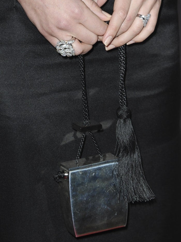 Margot Robbie showing off her rings and THE ROW's resin evening case clutch bag