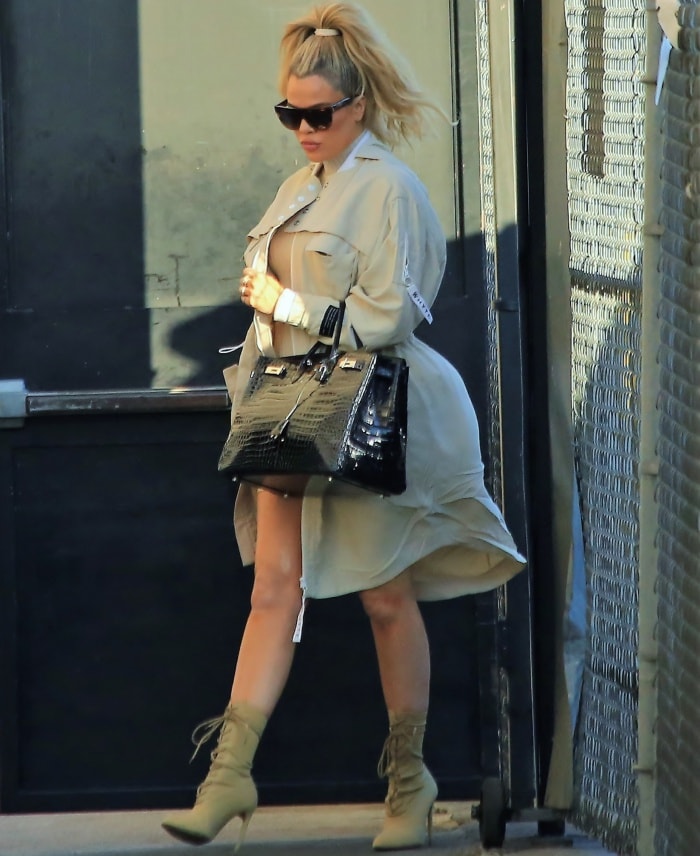Khloé Kardashian wearing a coat over a ribbed turtleneck dress and Yeezy lace-up boots at the "Jimmy Kimmel Live!" studios in Los Angeles