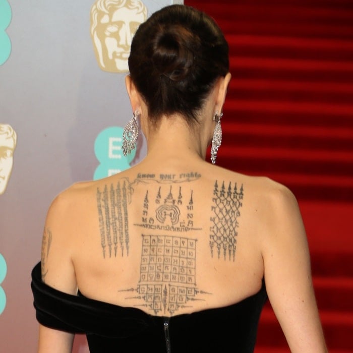 Angelina Jolie shows off her intricate Yant tattoos while wearing a custom Ralph & Russo Couture gown at the 2018 EE British Academy Film Awards