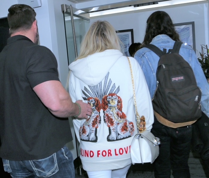 Kesha wearing an embroidered Gucci sweatshirt and toting Gucci's 'Thiara' medium top handle bag