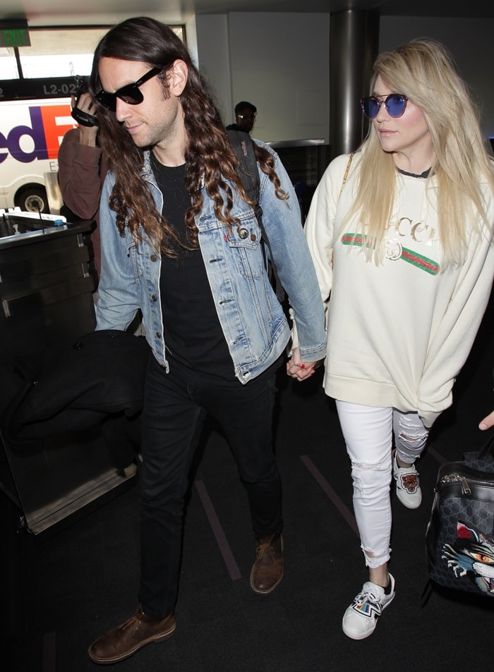 Kesha and her boyfriend Brad Ashenfelter were all cuddled up while making their way through LAX