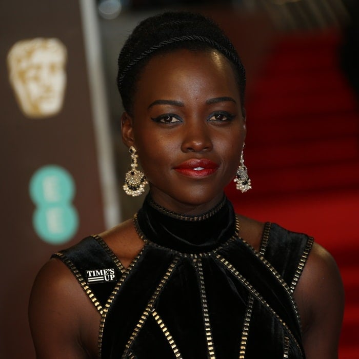 Lupita Nyong’o radiates elegance in a black velvet Elie Saab Couture gown, paired with statement earrings, at the 2018 British Academy Film Awards (BAFTAs)