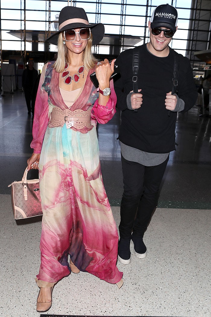 Paris Hilton pairing a pink-and-blue maxi dress with a nude Alaia laser-cut belt cinched over the waist