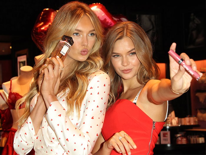 Romee Strijd and Josephine Skriver holding up the Victoria's Secret Love Eau de Parfum and Velvet Matte Cream Lip Stain.