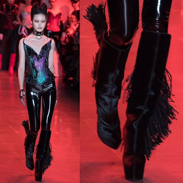 A model wearing a shimmery, reptilian-scale corset with Christian Louboutin for The Blonds black fringed slouchy platform boots.