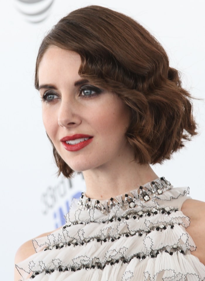 Alison Brie added a touch of glamour with jewelry by Brazilian-born designer Fernando Jorge and a striking rich watermelon lipstick