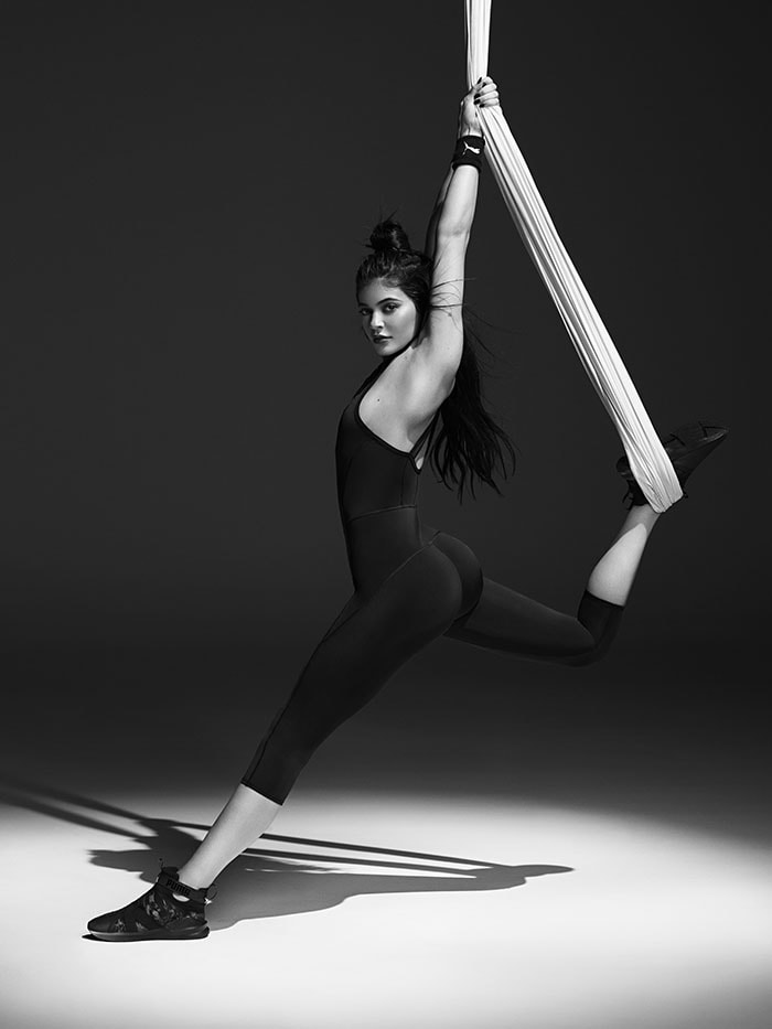 Kylie Jenner stretching with a fabric rope in the PUMA Swan Pack collection ad campaign.