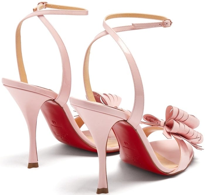They’re crafted in Italy from patent-leather lifted by a covered stiletto heel below slim wraparound ankle straps