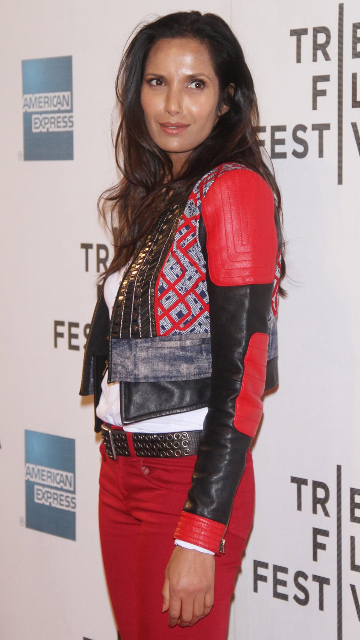 Padma Lakshmi stuns in red skinny jeans and a patterned leather jacket, adding a pop of color to her look