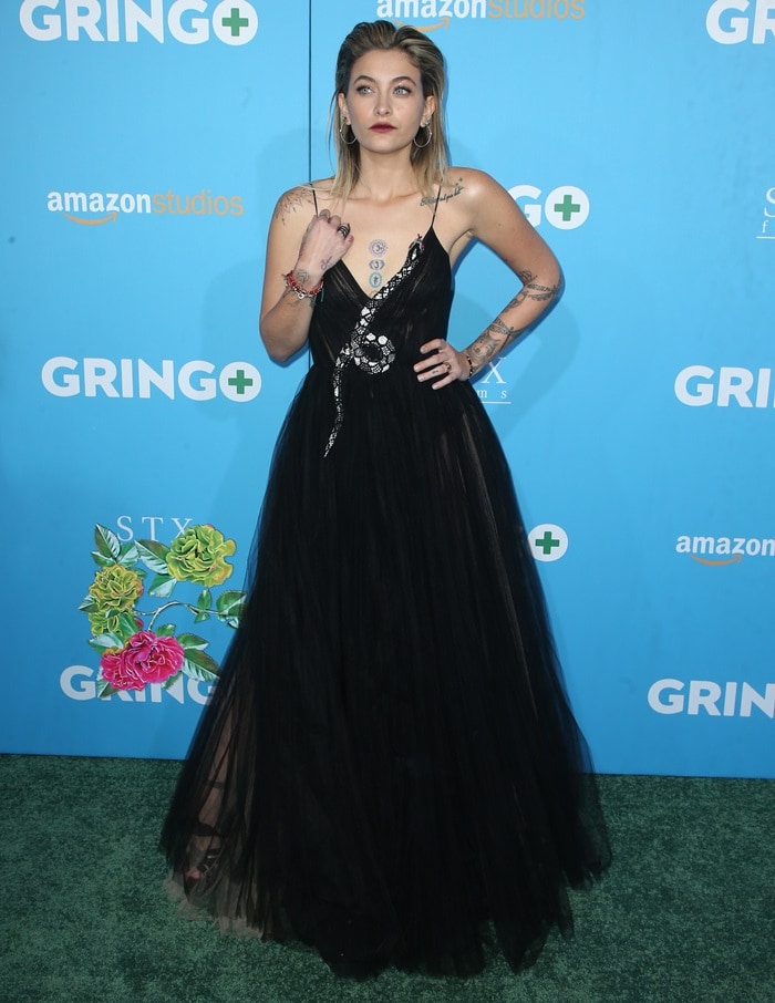 Paris Jackson dazzles in a flowing black Valentino gown featuring a striking snake embellishment that elegantly winds up the bodice