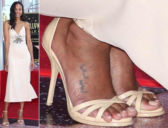 Zoe Saldaña shows off her feet in strappy nude sandals, revealing visible pressure marks and slight imperfections, likely caused by prolonged wear of high heels, as well as an Arabic tattoo on her foot