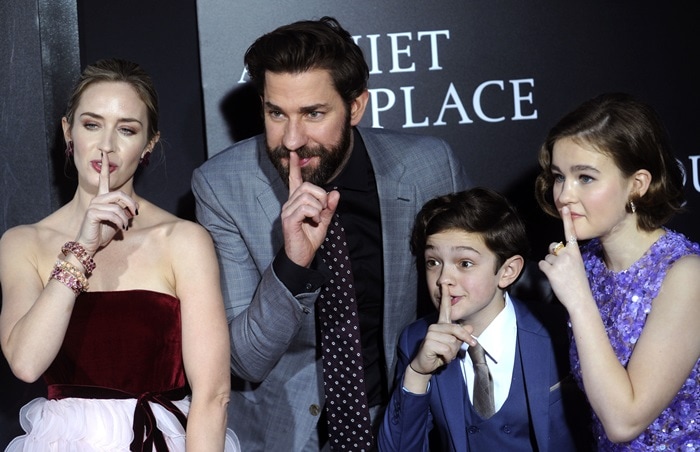 Emily Blunt, John Krasinski, Noah Jupe, and Millicent Simmonds strike a signature "silence" pose at the A Quiet Place premiere, perfectly embodying the film’s eerie suspense