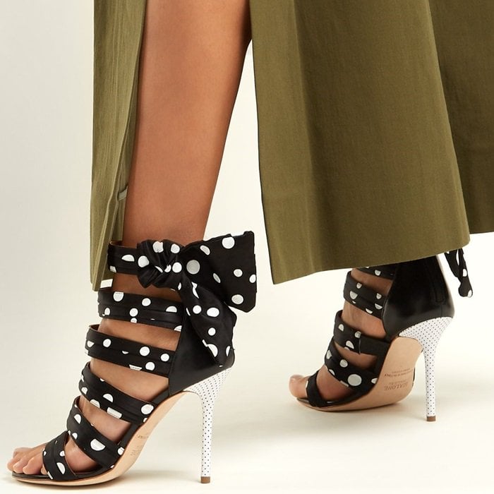 Graphic polka dots play out across the arched foot straps and side bows