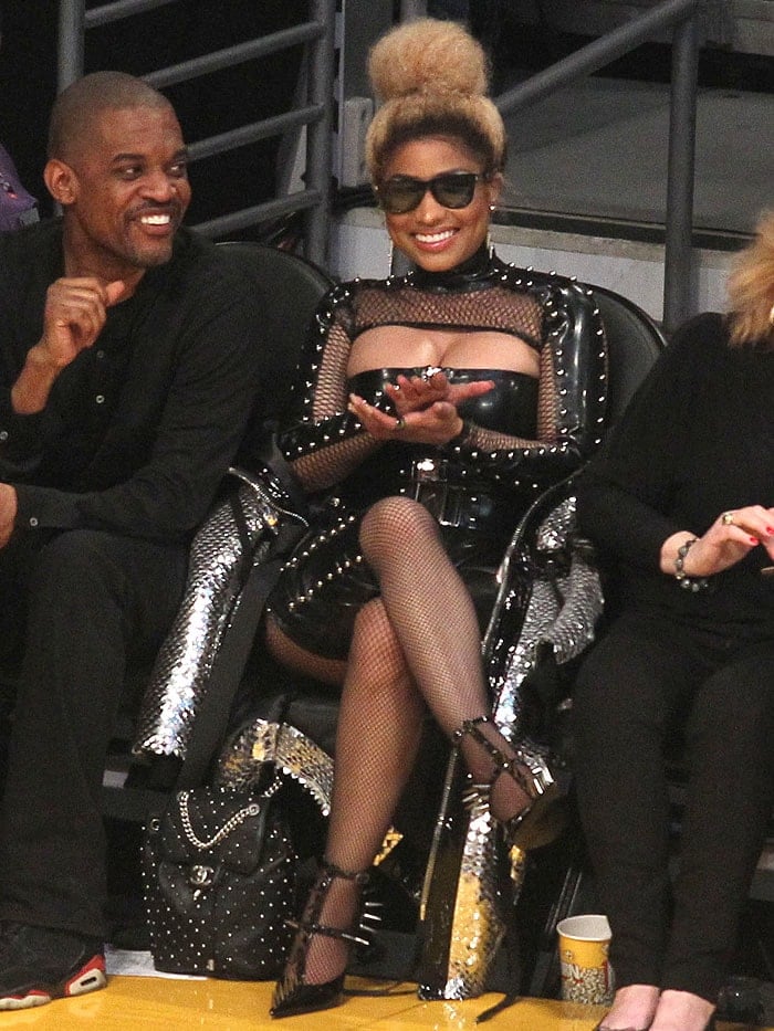 Nicki Minaj wearing a leather bodysuit, fishnets, spiked chaps, and spiked pumps.