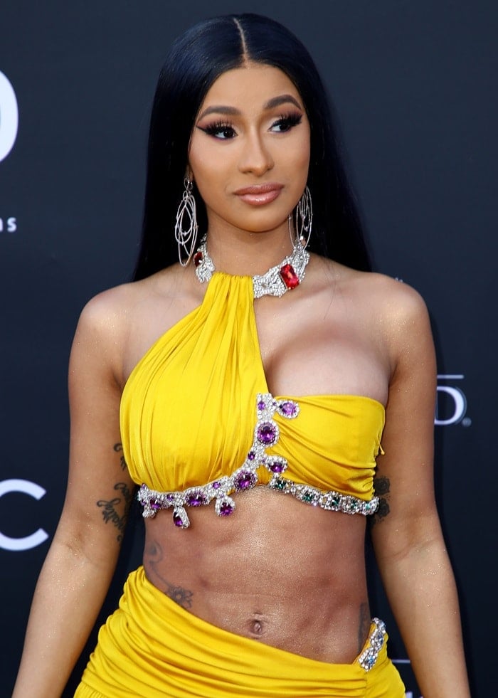 Cardi B showed off her belly button in a yellow, crystal-embellished halter top