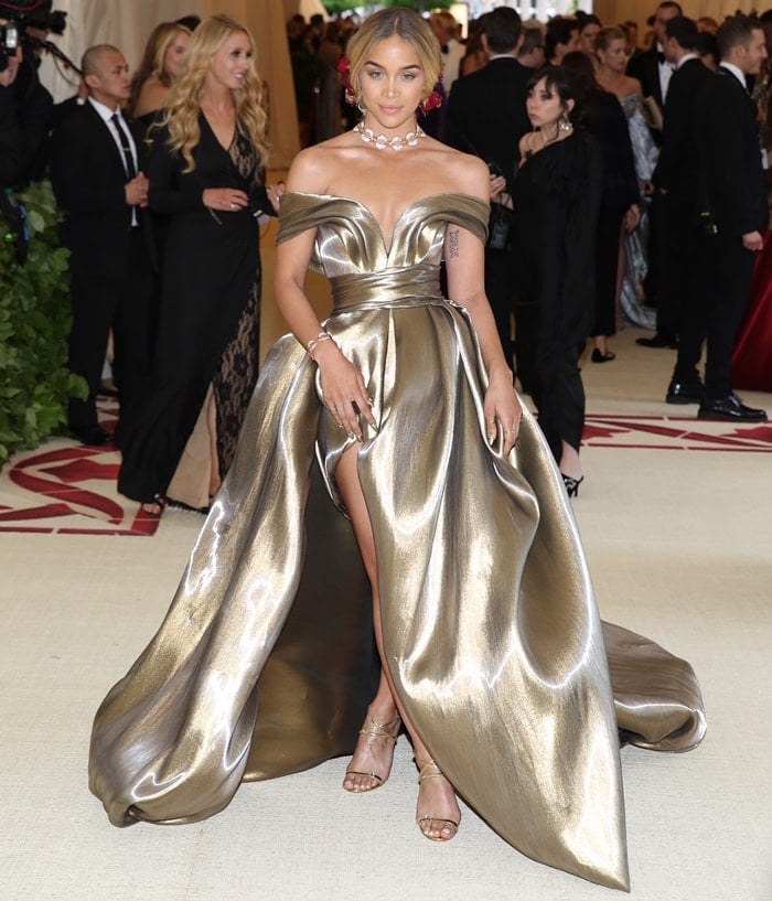 Jasmine Sanders wearing a custom golden gown featuring an off-the-shoulder neckline and thigh-high split