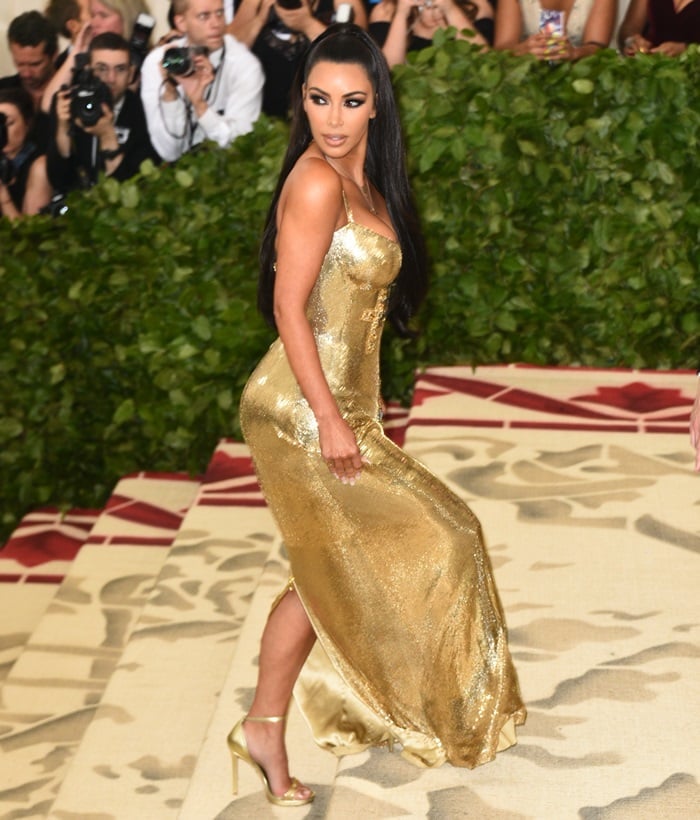 Kim Kardashian showing off her golden metallic ankle-strap sandals