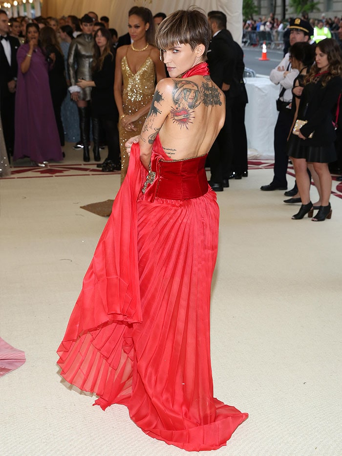 Ruby Rose wearing a Tommy Hilfiger red pleated dress with a velvet sash, gold Jimmy Choo 
