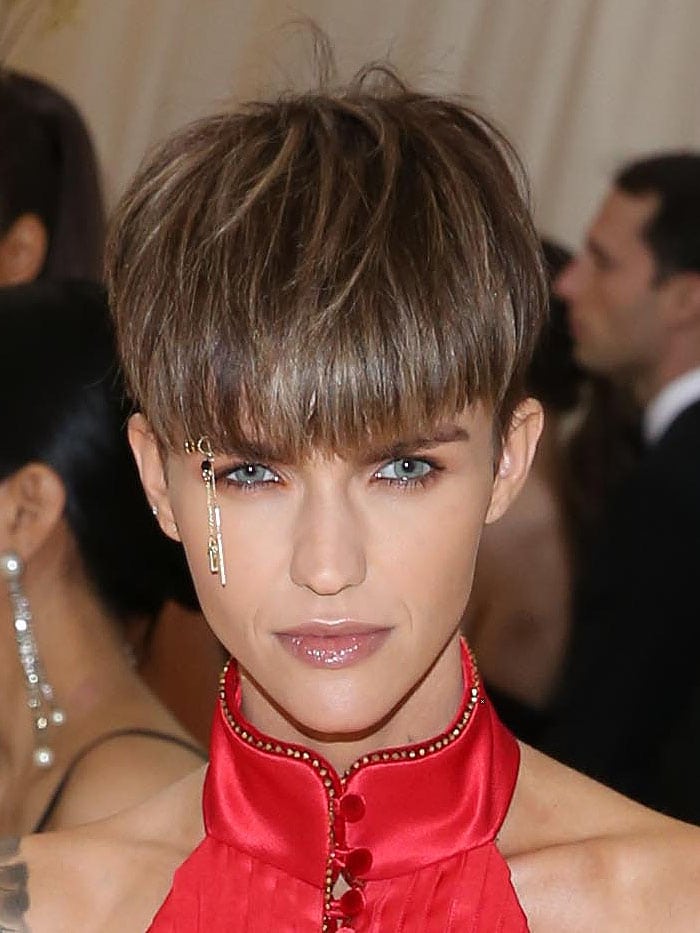 Ruby Rose wearing dangling gold crucifix eyebrow jewelry.