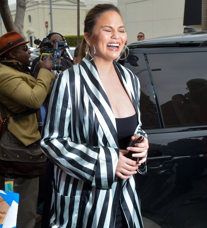 Chrissy Teigen's black and white stripe long sleeve midi robe jacket from Ann Demeulemeester