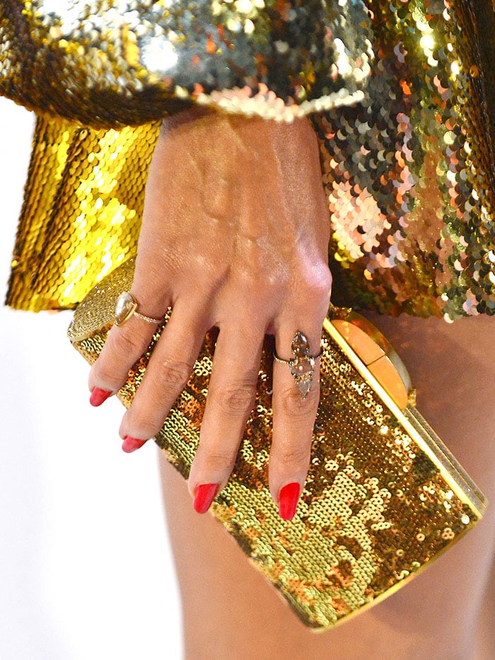 Details of Heidi Klum's gold sequined clutch against her Greta Constantine gold sequined dress.